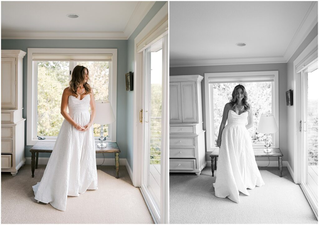 A bride stands beside a bedroom window smiling at an Iowa City wedding photographer.