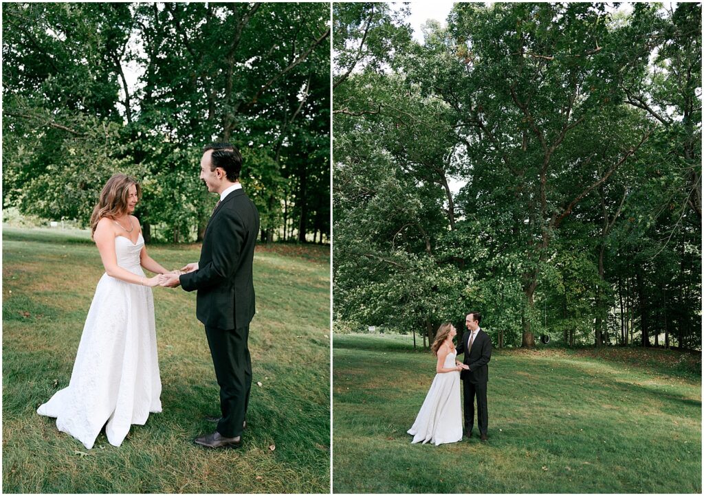 A bride and groom hold hands and smile during their first look on a lawn.