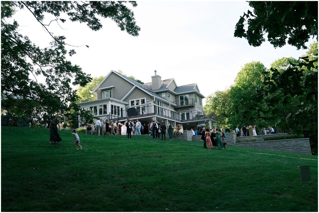 Wedding guests gather on the lawn of an Iowa City home for a wedding reception.