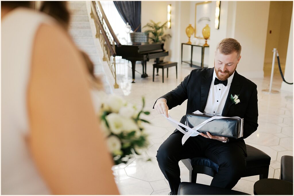 A groom opens a wedding gift.