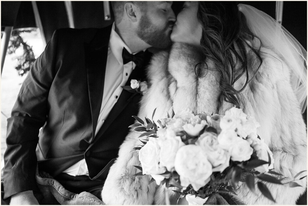 A bride and groom kiss in a carriage at their Davenport wedding.