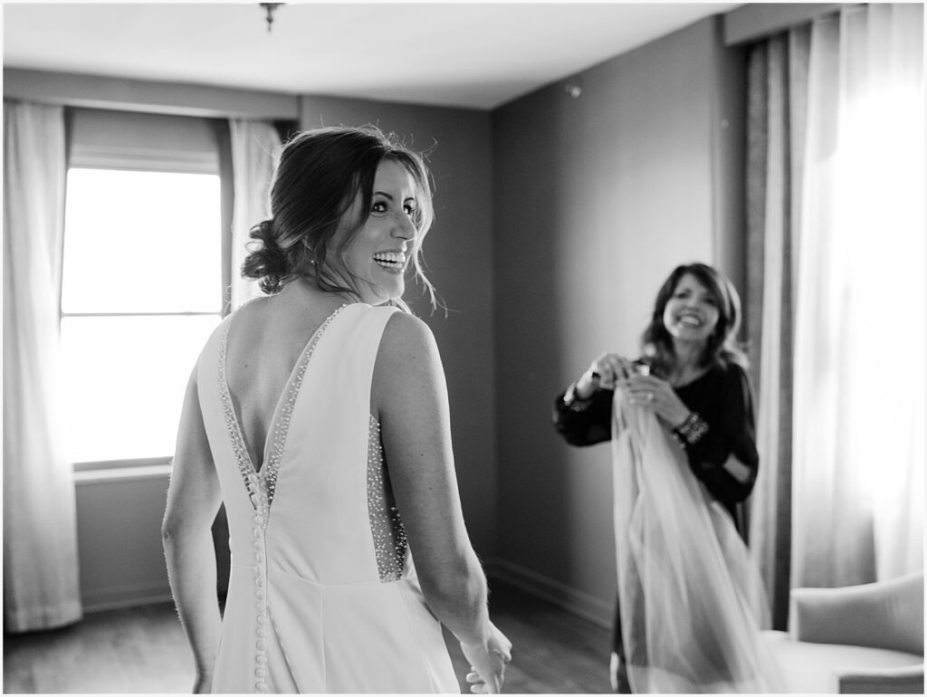 A bride looks over her shoulder and laughs.