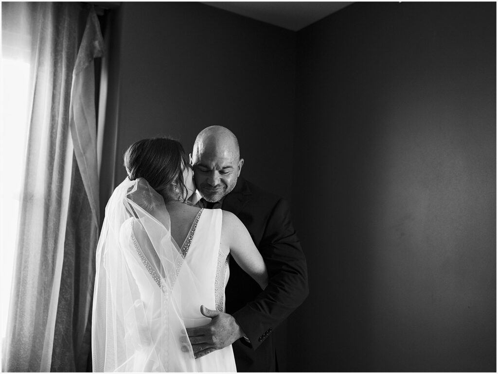 A bride and groom embrace during their first look in a Des Moines wedding venue.