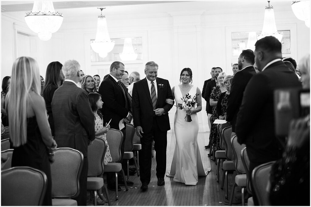 A bride's father walks her up the aisle at a Des Moines wedding.