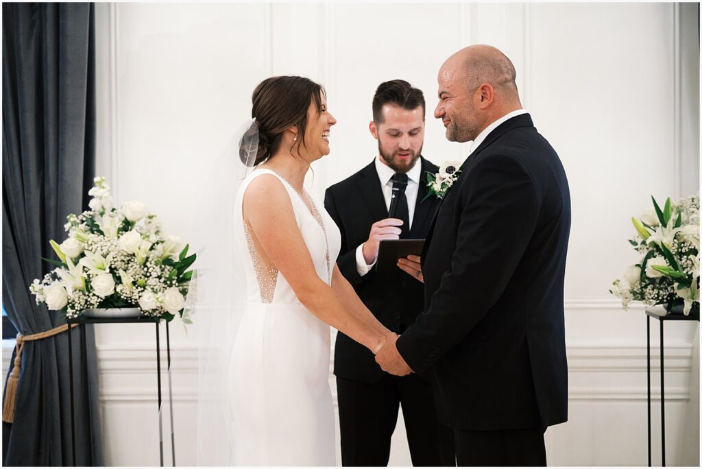 A bride and groom hold hands during a Hotel Fort Des Moines wedding ceremony.