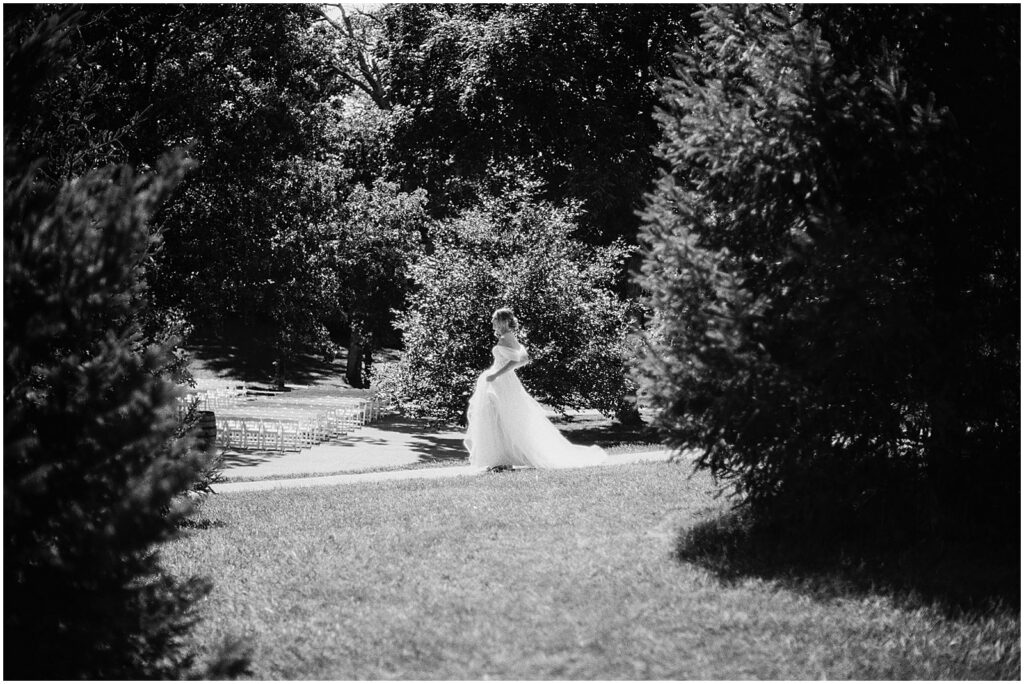 A bride walks through a garden carrying a bouquet at Wilson's Ciderhouse.