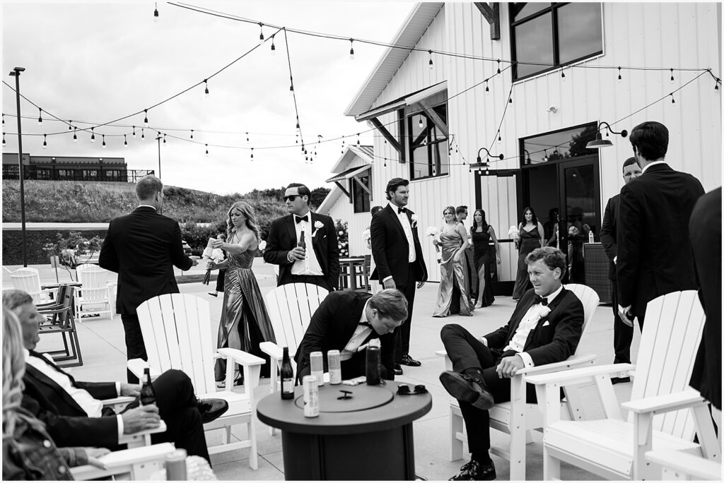 Wedding guests gather on a terrace for cocktail hour at an Eastern Iowa wedding venue.