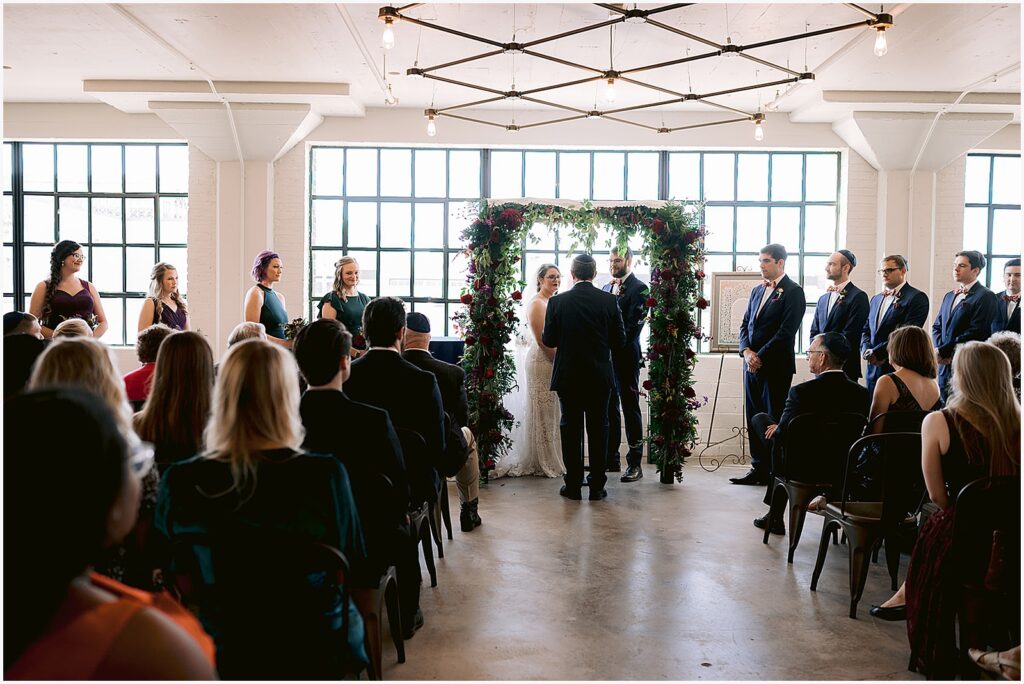 A bride and groom stand beneath a chuppah at a Jewish wedding in Iowa.
