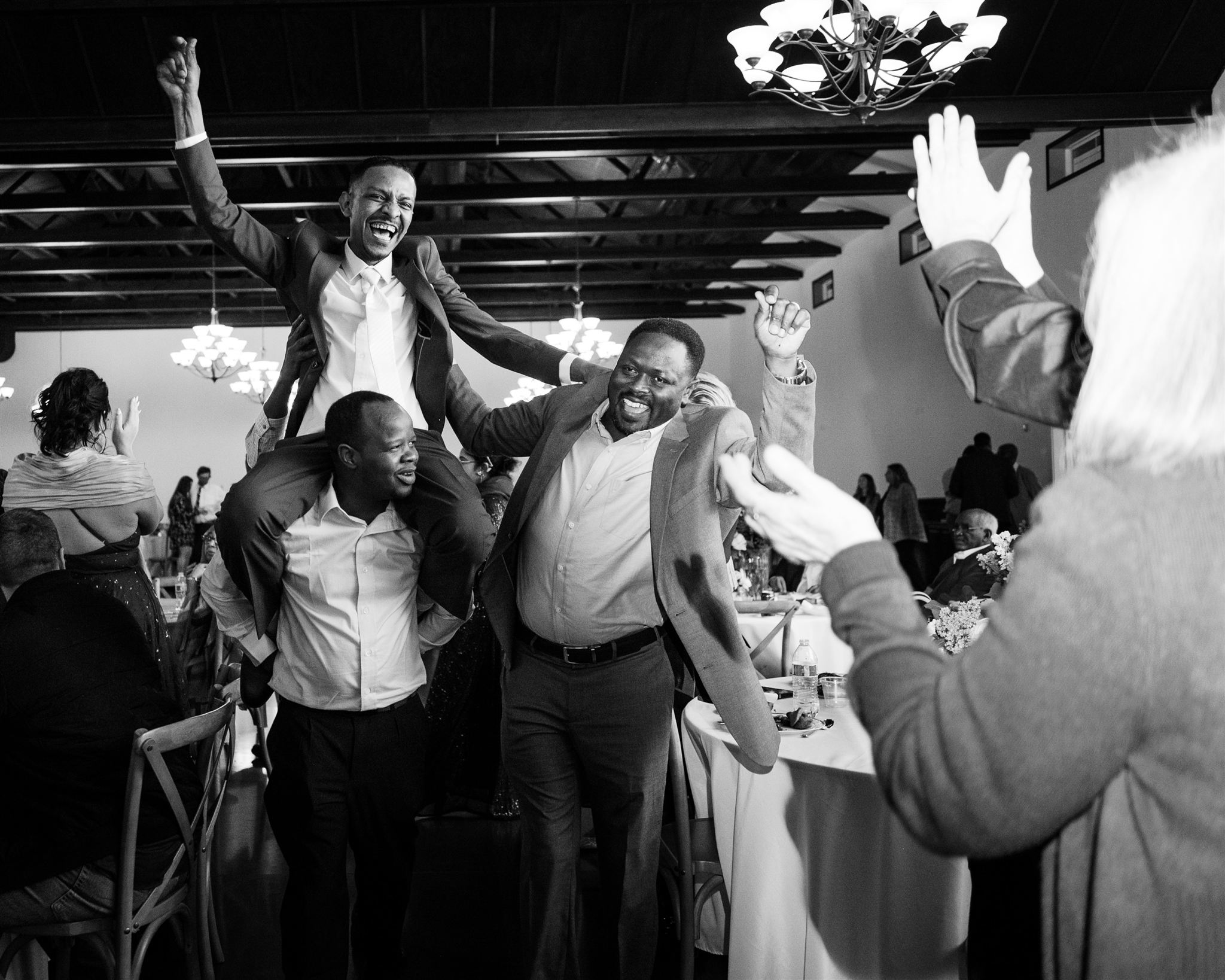 Groom and guests dancing during reception celebration documented in wedding photographer documentary style