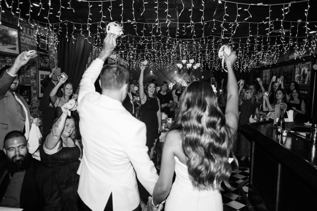 Bride and groom celebrating during speeches in meaningful moment in documentary-style wedding photography