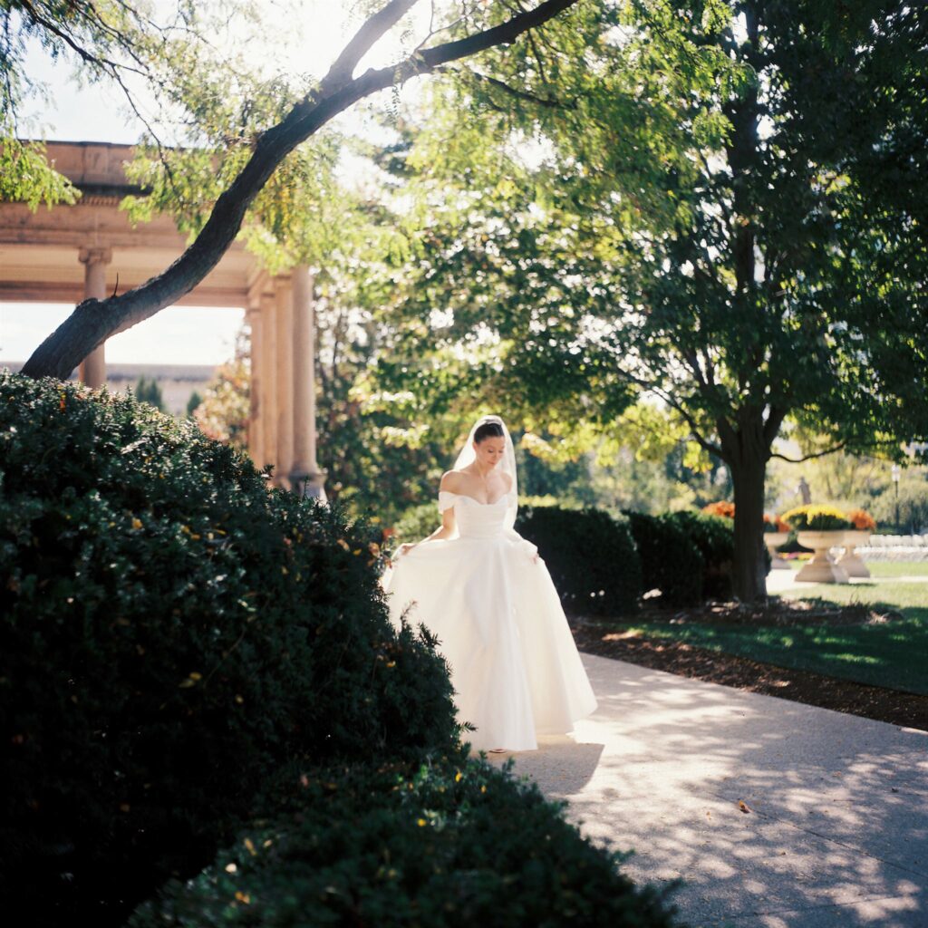 Bride in garden during a quiet moment, captured in a documentary style wedding photography approach